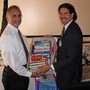 Through the organizational efforts of Dona Mast, the Rotary Club of Woodland President, Bob Nakken, presents books for a local school to the principal.